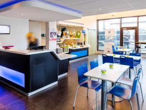 尼姆尼姆中心火车站宜必思快捷酒店的一间设有蓝色椅子和柜台及桌子的餐厅