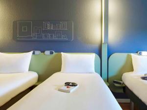 泰尔萨克阿尔比泰尔萨克宜必思酒店的一间设有两张床的房间,上面有一个盘子