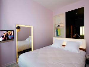 波尔多Mama Shelter Bordeaux Centre的卧室配有白色的床和镜子