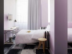 波尔多Mama Shelter Bordeaux Centre的一间卧室配有一张床、一张桌子和一张桌子