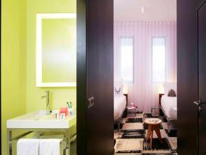 波尔多Mama Shelter Bordeaux Centre的一间带水槽、床和镜子的浴室