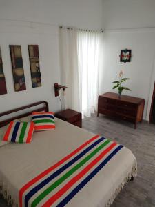 圣弗朗西斯科Cabaña Encanto de Luna的一间卧室配有一张带彩色条纹毯子的床