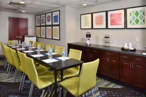 塞尔玛塞尔马智选假日套房酒店的一间会议室,配有长桌子和黄色椅子