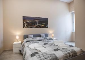 那不勒斯Casa Cavaliere的卧室配有一张床,墙上挂有绘画作品