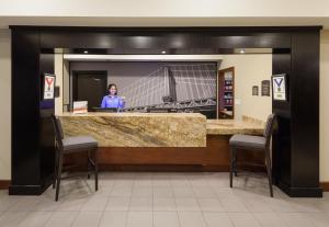 泰勒泰勒大学区驻桥套房酒店的站在大厅柜台后面的女人