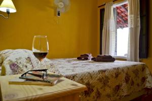 圣哈维尔Posada Villapancha的睡在床上的一杯葡萄酒