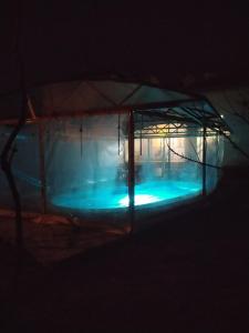 丘斯滕迪尔Къща за гости с минерална вода "Терма Асклепий"的游泳池,在黑暗中设有帐篷