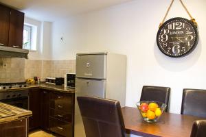 萨格勒布Zagreb Creative Apartments APP 2的厨房配有桌子和墙上的时钟