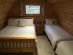 基尔基Emlagh, Self Catering Glamping Pods的小木屋内的两张床,设有窗户