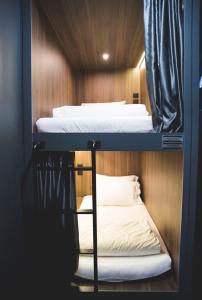 新加坡Wink at McCallum Street的木墙客房的两张双层床