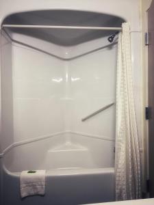 迪凯特Lone Star Inn的浴室内设有带浴帘的白色浴缸
