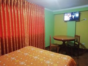 瓦拉斯Residencial Norandes的配有床、桌子和电视的房间