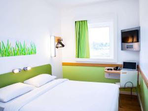 大坎普ibis budget Campo Grande的绿色和白色的卧室设有床和窗户