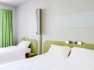 布拉加布拉加中心宜必思快捷酒店的一间卧室配有两张白色的床和绿色窗帘