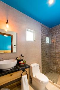 萨尤利塔Riviera Sayulita Hotel的一间带卫生间、水槽和镜子的浴室
