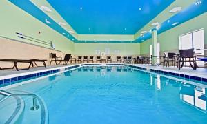 PerryvilleHoliday Inn Express & Suites - Perryville I-55, an IHG Hotel的一个带桌椅的大型游泳池