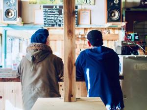 松山Bakushuku Den Guest House Brew的两人坐在餐厅柜台