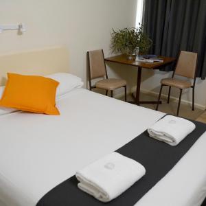 TemoraShamrock Hotel Motel Temora的一间卧室配有一张床,上面有两条毛巾