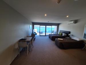 Te KahaTe Kaha Beach Hotel的带沙发、床和桌子的客厅
