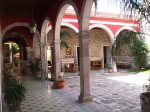 莫雷利亚利蒙切罗住宿加早餐旅馆的建筑中种有拱门和盆栽植物的庭院