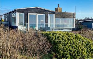 埃斯比约Nice Home In Esbjerg V With Wifi的一座带大型玻璃窗和灌木的房子
