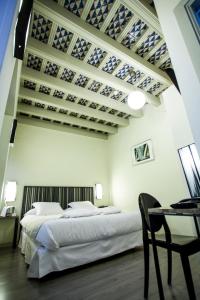 塞维利亚圣克鲁斯之家精品酒店的一间卧室配有一张床和一张桌子及椅子