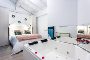 埃尔瓦Apartamentos Hervás Suites的一间卧室配有一张床和一个镜子浴缸