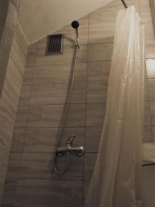 考纳斯Jurgis Guest house的带淋浴头和浴帘的淋浴