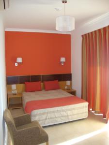 曼塔罗塔曼塔玛公寓式酒店的一间卧室设有一张床和红色的墙壁