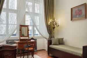 布拉格布拉格大酒店的一间卧室配有一张床、一张书桌和一个窗户。