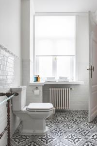 奥斯坦德因特迪特住宿加早餐旅馆的白色的浴室设有卫生间和窗户。