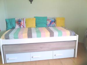 塔维拉le Boucanier的床上配有色彩缤纷的毯子和枕头