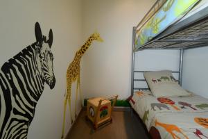 LonnyLe Moulin d'Harcy的卧室的墙上装饰有斑马和长颈鹿