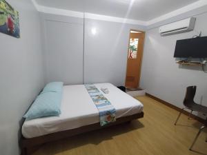 马尼拉JB Valdres Apartment的一间卧室配有一张床和一台电视