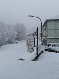 蒙绍Villa Burgau B&B的街道灯旁的雪地里的一个街道标志