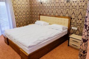 日托米尔Оздоровчий комплекс Гайки заїзд провулок Сухий Яр 12的卧室内的一张带白色床单和枕头的床