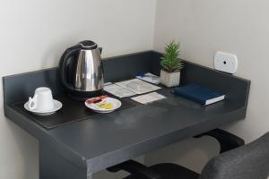 圣保罗保利斯塔花园酒店的一张带咖啡壶和茶壶的黑色办公桌