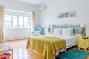 里斯本Casa da Avenida Lisboa的一间卧室配有一张带黄色毯子的大床