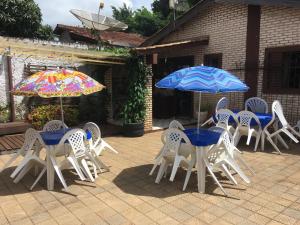 沙帕达-杜斯吉马朗伊斯Zizi Home的一组桌椅和遮阳伞