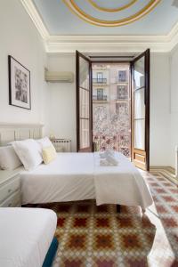 巴塞罗那赫罗纳旅馆的一间卧室设有两张床和大窗户
