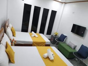 曼巴豪Camiguin KALIMBA DE LUNA INN的客房设有两张床和一台平面电视。