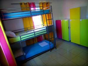圣弗朗索瓦Butterfly Hostel的客房设有两张双层床和色彩缤纷的橱柜。