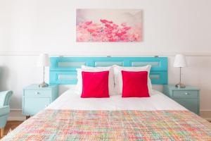 里斯本Casa da Avenida Lisboa的一间卧室配有一张带两个红色枕头的床