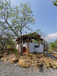 巴里查拉NOMAD Hostal - Barichara的一座小房子,有树和一座建筑