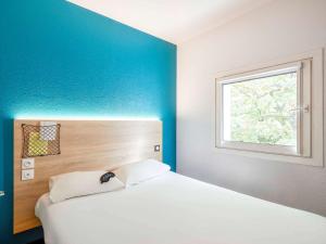 维勒纳夫多尔农hotelF1 Bordeaux Sud Villenave d'Ornon的卧室配有白色的床和窗户。