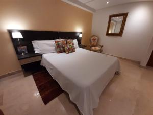 哥伦比亚港Porto Bello Hotel Boutique的卧室配有一张白色大床和镜子