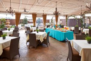 圣地亚哥Empress Hotel La Jolla的餐厅配有白色的桌椅和蓝色的桌布