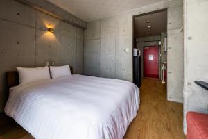 那霸Hotel Little Island Okinawa Matsuyama的卧室配有一张白色大床和一张红色沙发