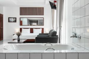 万象S 2 Modern Boutique Hotel的白色的浴室设有浴缸和床。