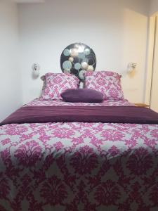 沙特拉永普拉日Appart Madame à Chatelaillon plage 2 pers的一张带紫色毯子和枕头的床